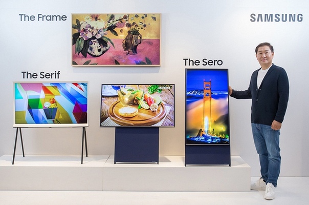 Компания Samsung представила несколько моделей телевизоров, среди которых выделяется Sero — аппарат с 43-дюймовым экраном QLED. Его необычной чертой является возможность поворота экрана на 90°, встречающаяся только у компьютерных мониторов. По словам производителя, вертикальная ориентация хорошо подходит для просмотра видеороликов, снятых смартфоном в такой же ориентации. Кроме того, на вертикальном экране удобнее смотреть страницы Instagram и других сервисов, особенно если под видео публикуются комментарии. Конечно, на телевизор можно выводить изображение со смартфона. Для облегчения подключения используется NFC. Телевизор оснащен многоканальной звуковой подсистемой (4.1) мощностью 60 Вт. Он обеспечивает доступ к виртуальному голосовому помощнику Bixby. Хотя производитель не уточняет этот момент, разрешение экрана, скорее всего, равно 4K. В Южной Корее продажи новинки начнутся в мае по цене около 16 000 долларов.