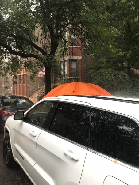 Прохожий увидел что у автомобиля открыт люк во время дождя и закрыл его своим зонтиком. Человек с добрым сердцем.